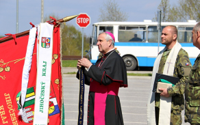 Biskup Kročil připeňuje stuhu na bojový prapor pěší roty AZ